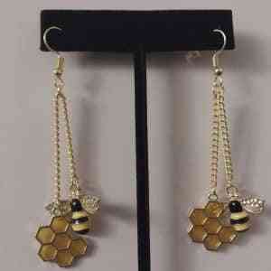Fidget earrings featuring bees and honeycomb.