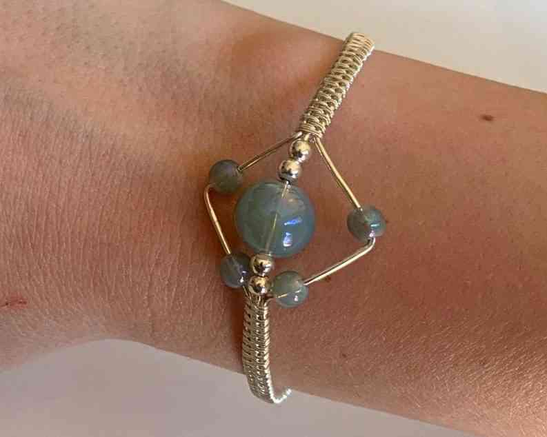 Stim bracelet -- wire jewelry with blue spinning stones for fidgeting.