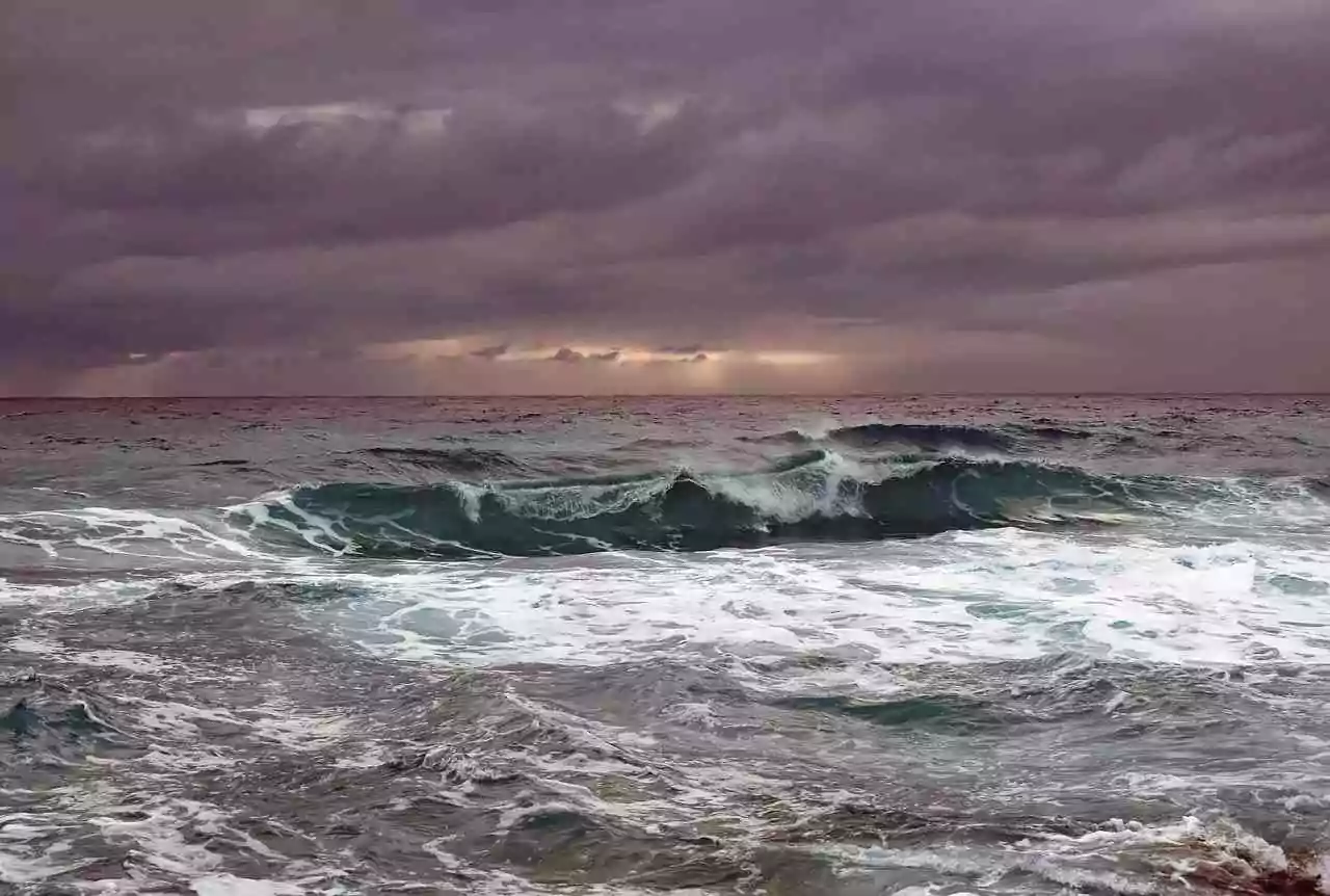 Healing from trauma is an ongoing cycle, like the tides of an ocean. Image shows ocean waves during a storm.