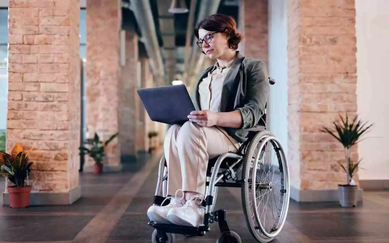 Wheelchair user at work in the UK where disabled employees are protected by the Equality Act.
