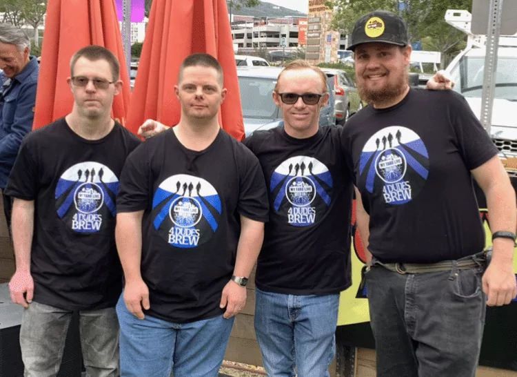 The 4 dudes, beer brewers with developmental disabilities, wearing their logo shirts.