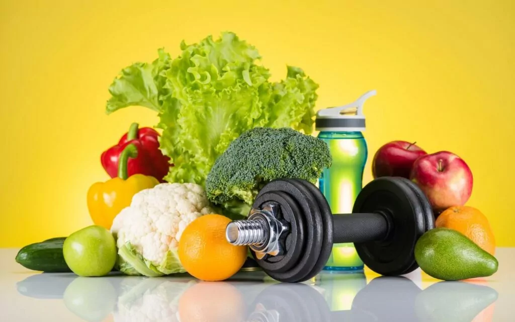 Weights, water bottle and fresh vegetables