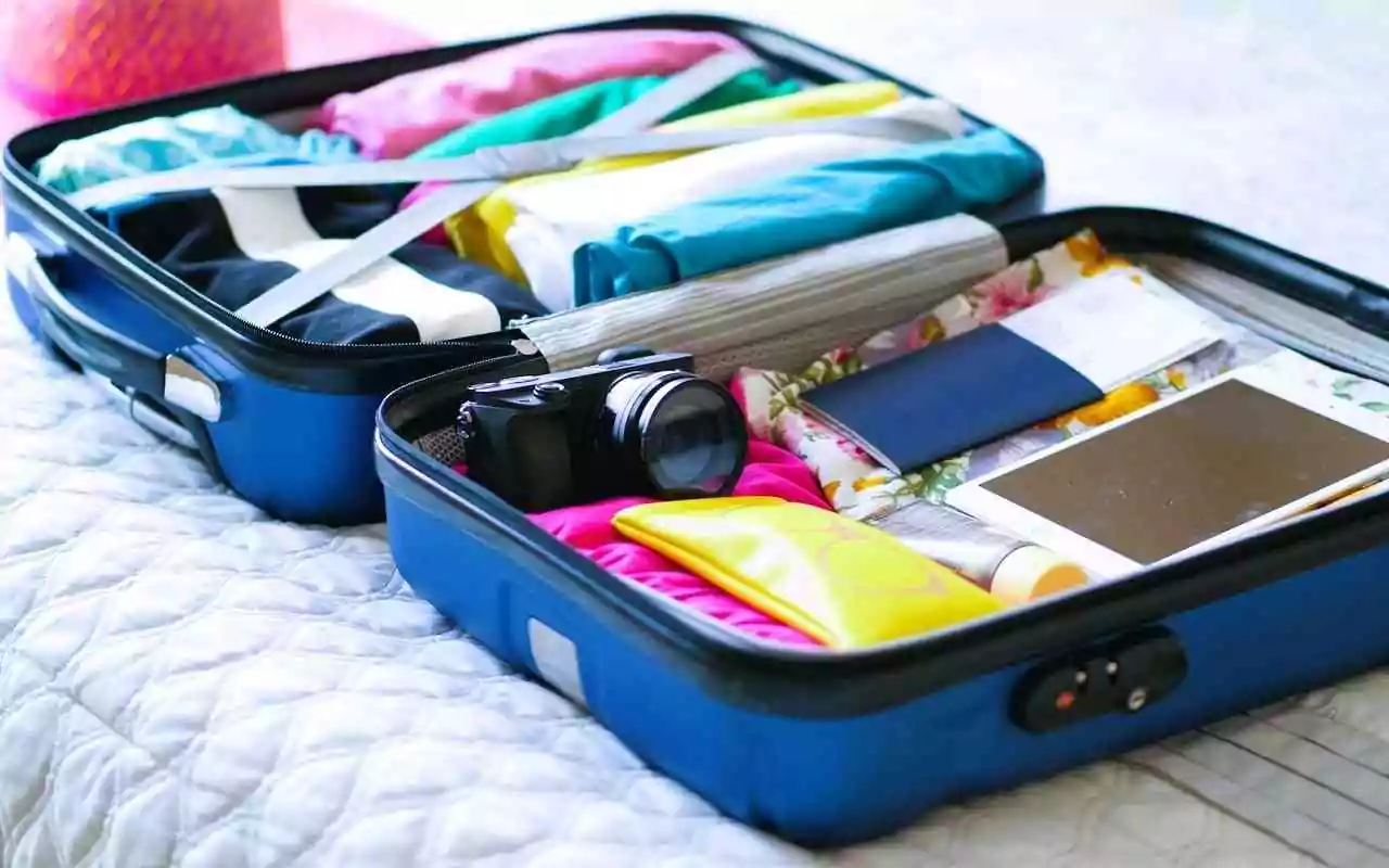 Tips for traveling with a disability. Open packed suitcase on a bed.