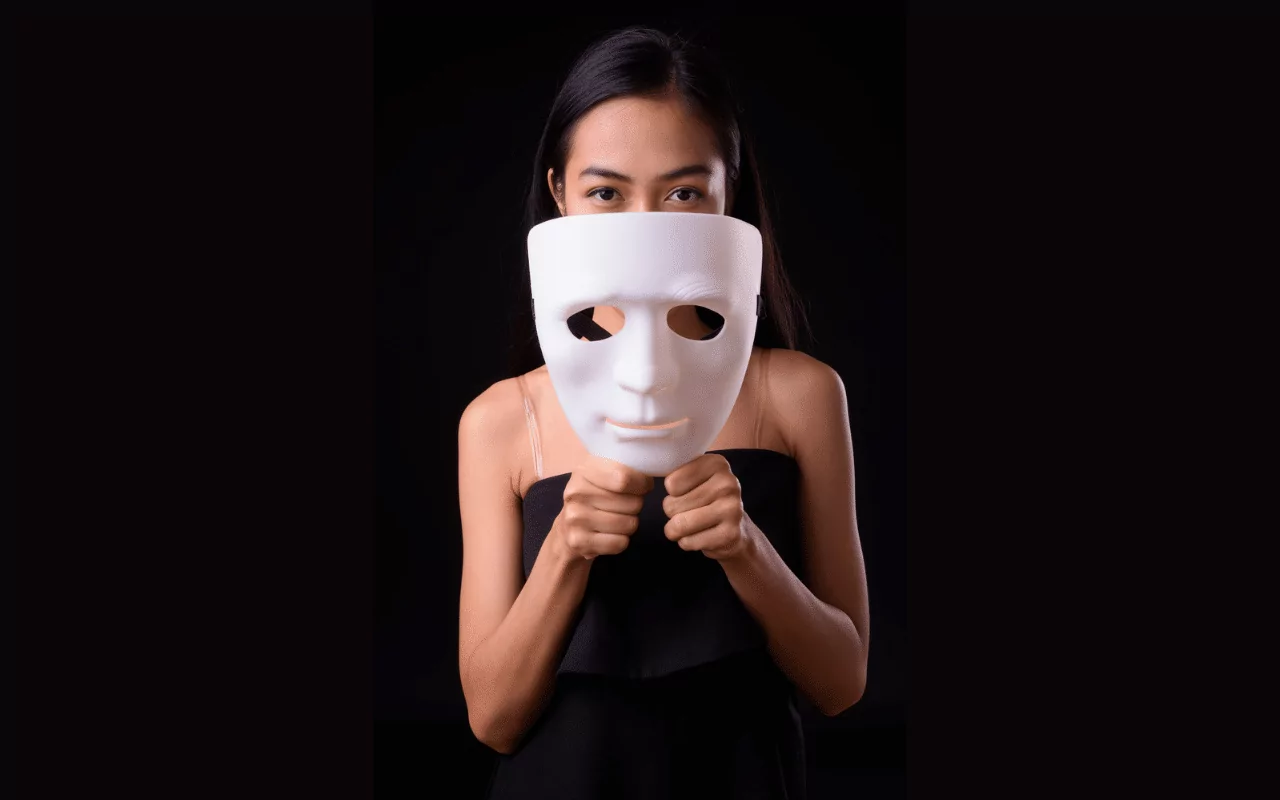 Autism masking. Woman lifting mask away from her face.