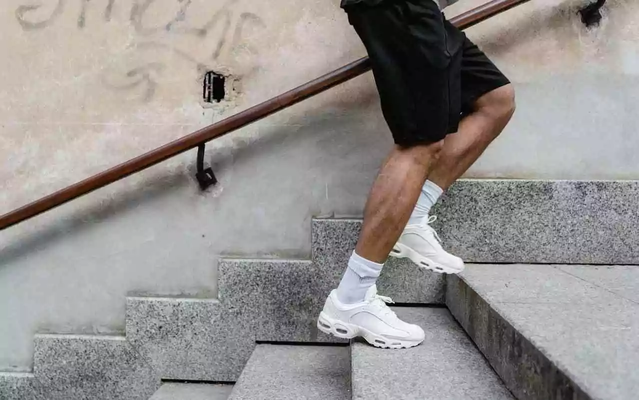 Small steps to fine-tune your mental health recovery. A man in running shoes climbing stairs.