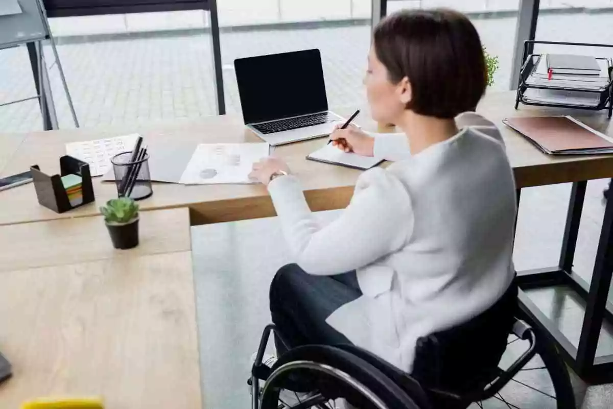 Woman in wheelchair who is a business owner at her desk.