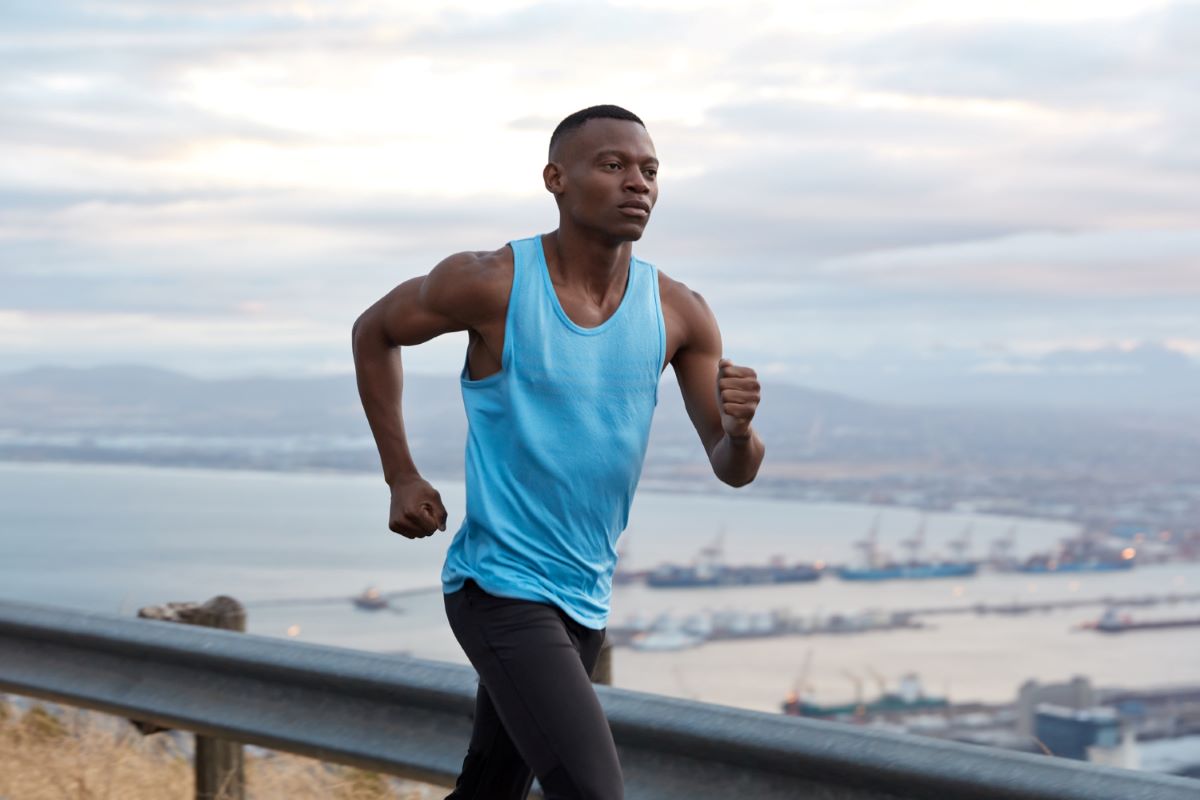 Cardiorespiratory fitness exercises for men. Man jogging near the ocean.
