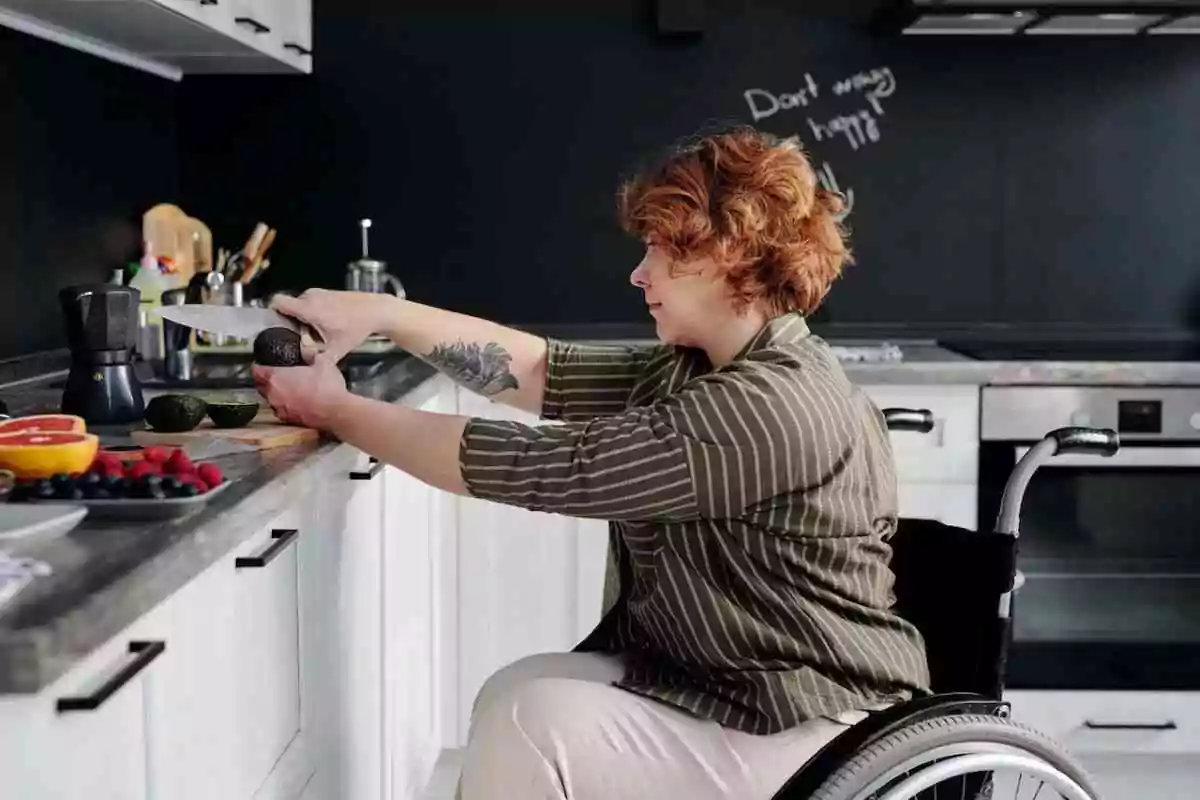 Woman in wheelchair cooking in the kitchen.