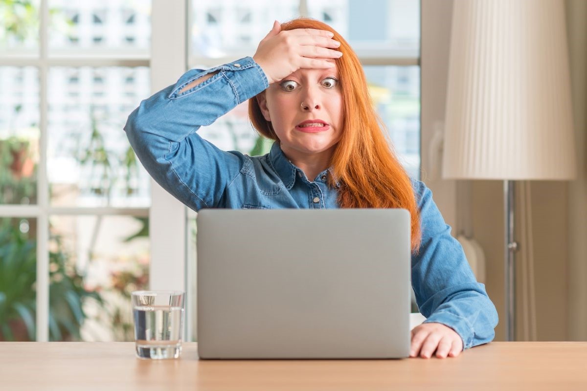 Outraged and frustrated woman looking at computer screen.
