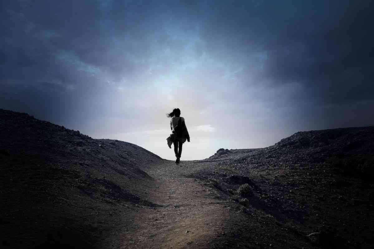 Struggling to get a mental illness diagnosis. Woman walking alone on a mountain path.