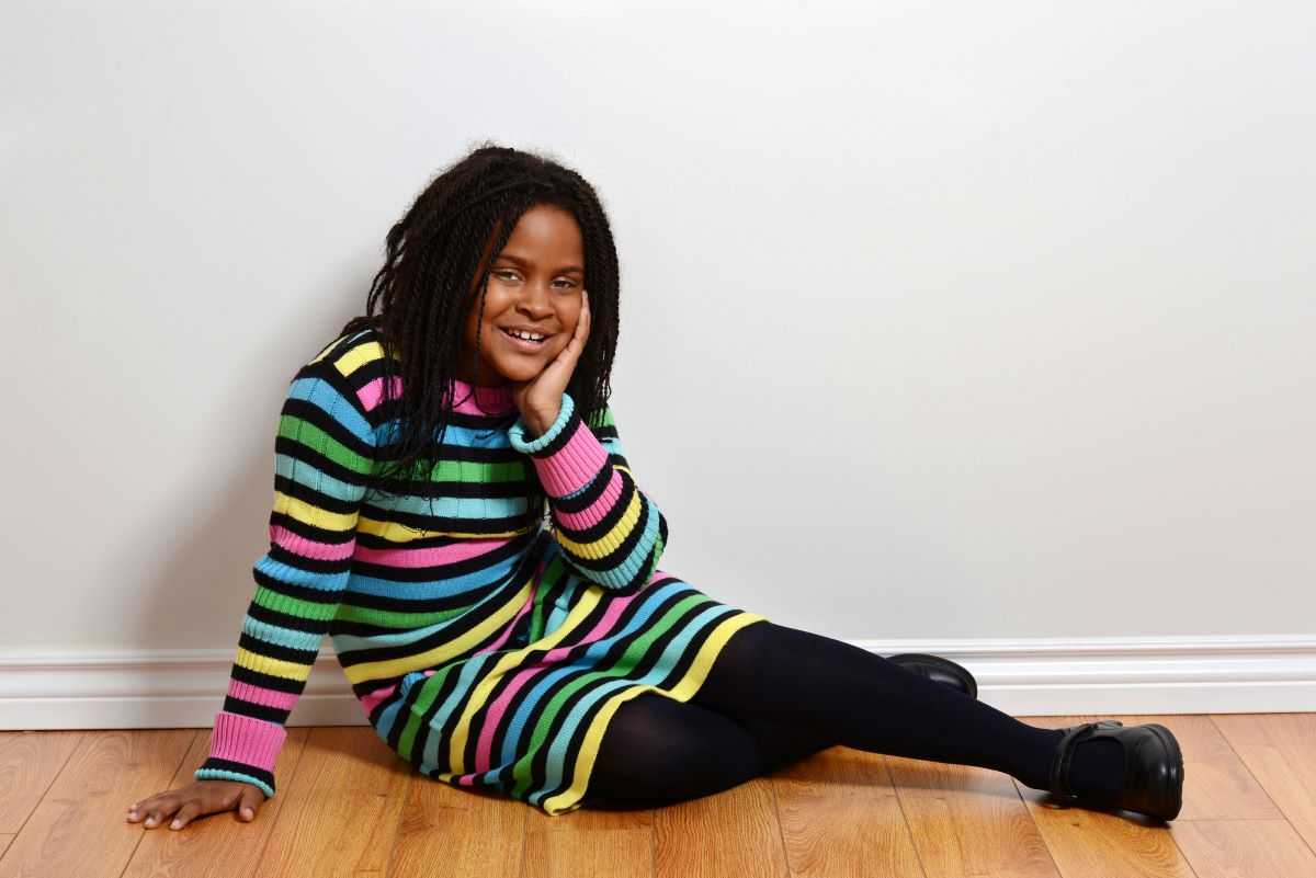 African American girl wearing striped dress.