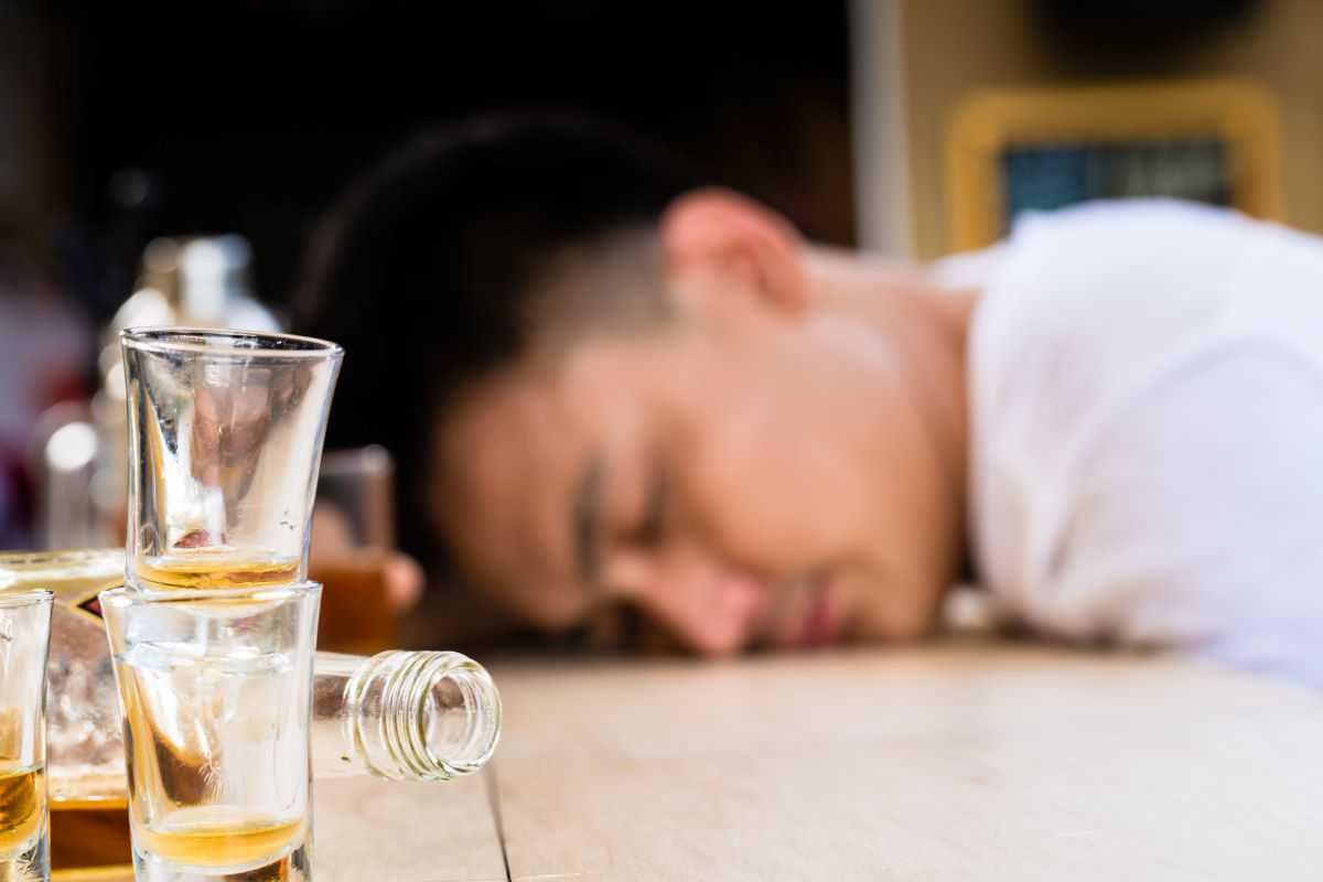 College student passed out near glasses of alcohol.