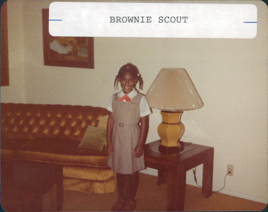 Alisa wearing her Brownie uniform as a child.